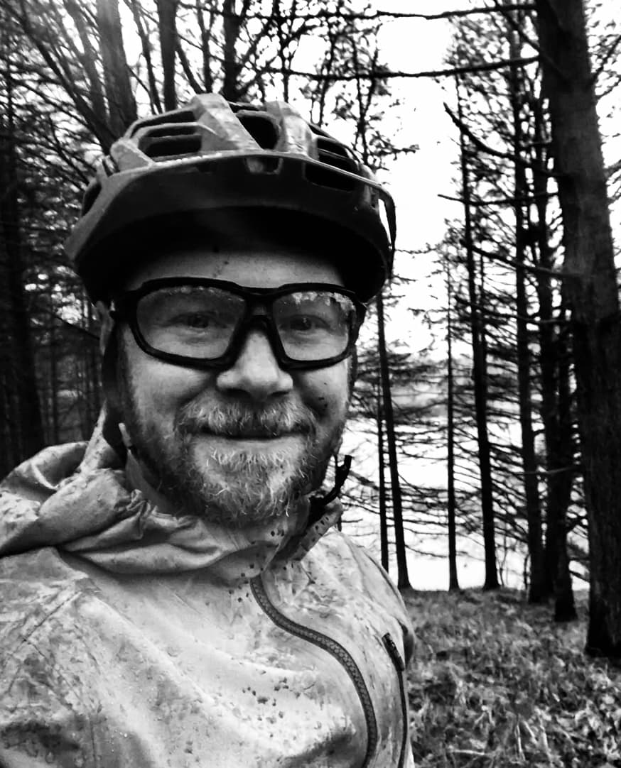 Daniel wearing a mountain bike helmet in woodland, reflecting his interest in the outdoors