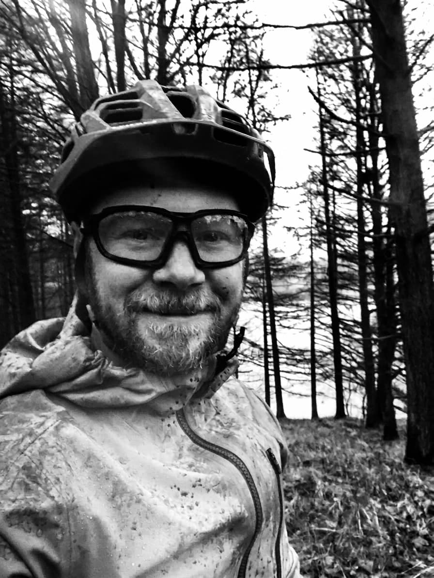 Daniel wearing a mountain bike helmet in woodland, reflecting his interest in the outdoors