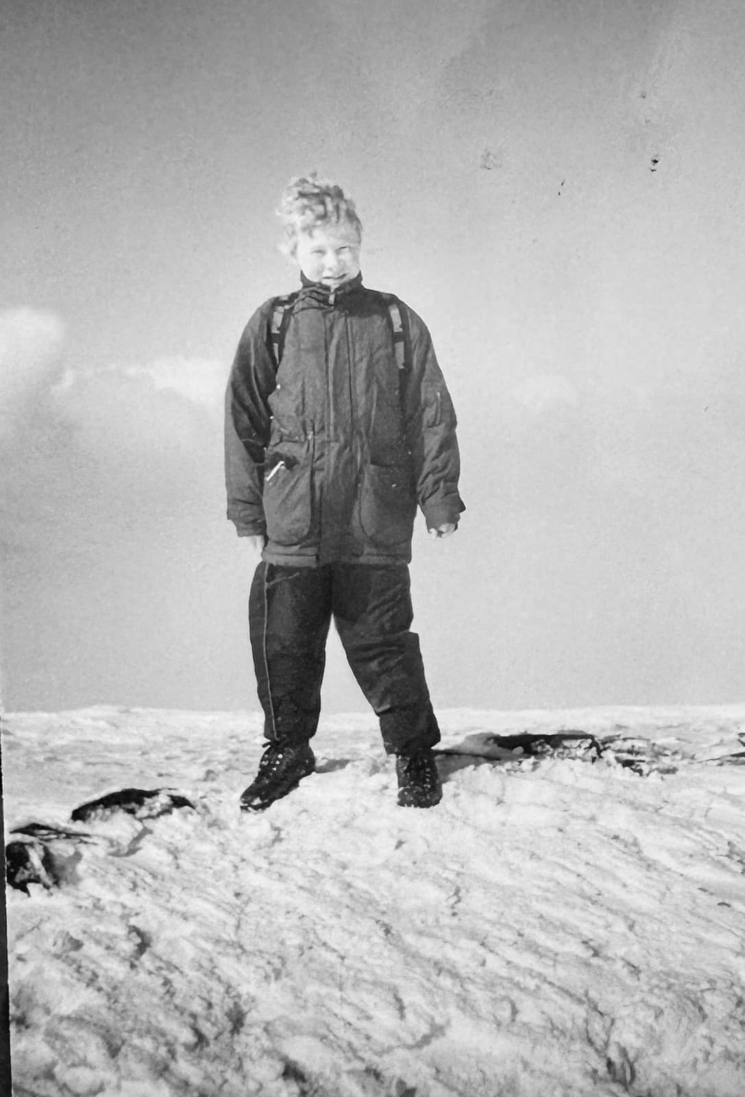 Childhood photo of Daniel Bellerby wearing snow gear on a mountainside, reflecting his lifelong interest in the outdoors